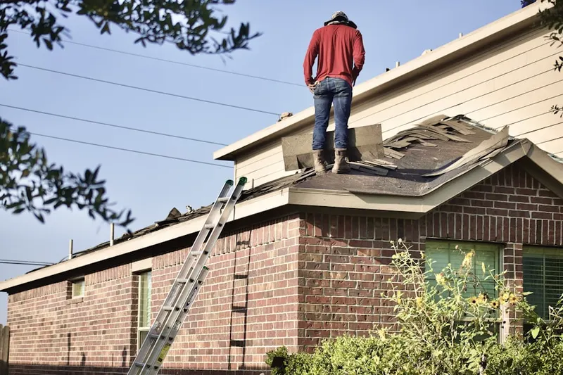 Professional roofer working on a residential roof in Hop Brook